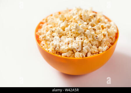 An orange bowl with popcorn isolated on white background. Food concept Stock Photo