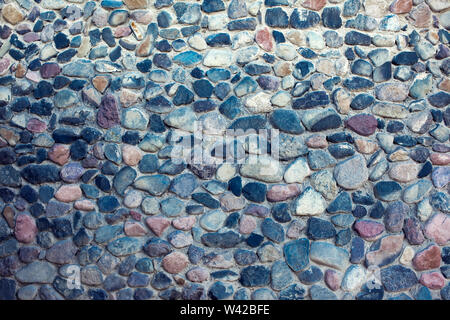 Natural colorful pebbles background on beach in summer for wall design and natural background concept in summer. Stock Photo