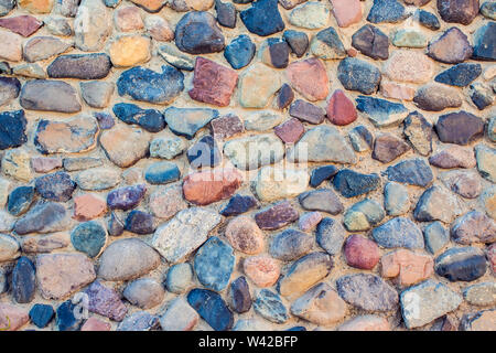 Natural colorful pebbles background on beach in summer for wall design and natural background concept in summer. Stock Photo