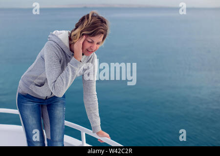 Cruise sea motion sickness tourist woman seasick on boat vacation with headache. Fear of travel or illness virus on cruising holiday. Stock Photo