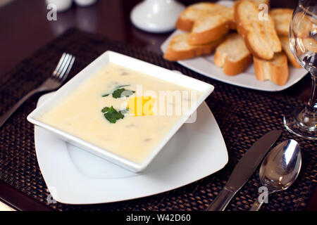 Cream soup and bread croutons on the table in cafe Stock Photo