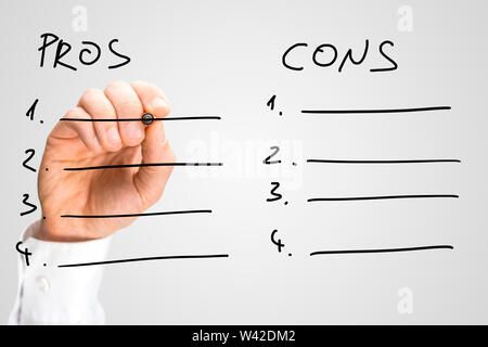 Man drawing up a list of pros and cons on a virtual interface or screen with a marker pen in order to make a decision in a conceptual image, close up Stock Photo