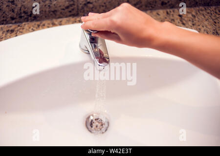 Open chrome faucet water washbasin in the bathroom. Stock Photo