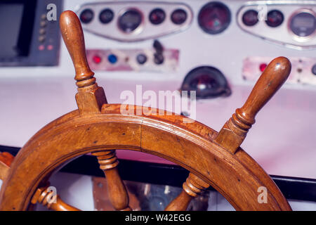 Wooden steering wheel and control panel on a yacht. Stock Photo