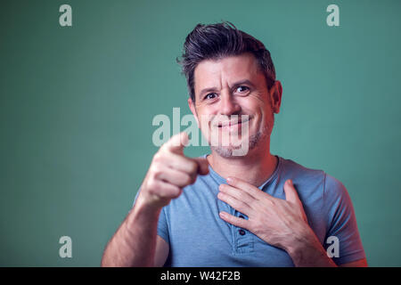 People, lifestyle and emotions - a portrait of man smiles and points with a finger at camera Stock Photo