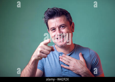 People, lifestyle and emotions - a portrait of man smiles and points with a finger at camera Stock Photo