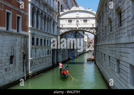 View of the Bridge of Sighs from the Rio de Palazzo with passing tourist enjoying rides in gondolas,Venice,Italy Stock Photo