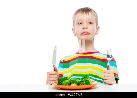 Boy disgusted with eating broccoli, portrait isolated on white background Stock Photo