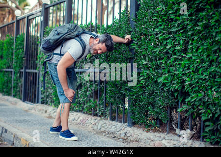 Man having knee pain on the street. People, healthcare and medicine concept Stock Photo