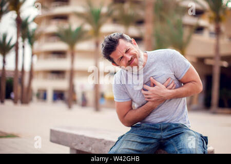 Man suffering from heart attack outdoors. People, health care and medicine concept Stock Photo