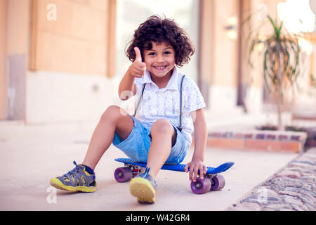 Little Boy With Curly Hair With Skateboard Outdoor Children And