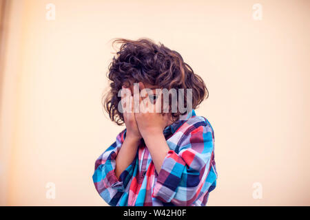 Closeup portrait of shy little kid with curly hair Stock Photo