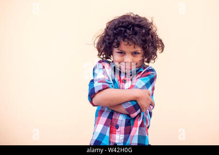 Closeup portrait of shy little kid with curly hair Stock Photo