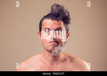 A portrait of man with half beard and hair on brown background Stock Photo