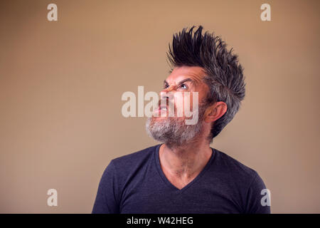 Closeup portrait of an angry adult man with a beard and iroquois. People and emotions concept Stock Photo