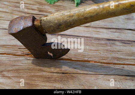 Vintage ax stuck in wood casting shadow on wood. Stock Photo