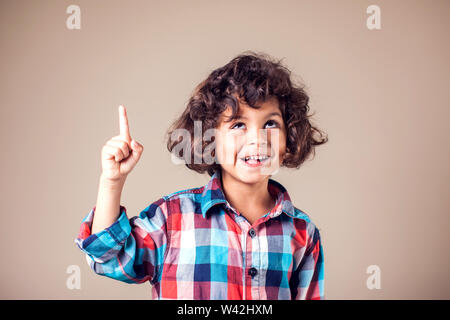 Portrait of cheerful boy with good idea - isolated over grey background Stock Photo
