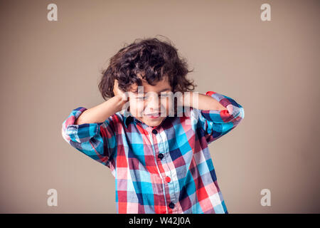 Young boy with covering his ears with hands.Children and emotions concept Stock Photo