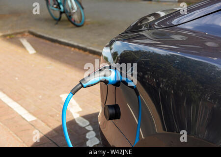 Charging the electric vehicle battery . EV fuel Plug in hybrid car close up view Stock Photo