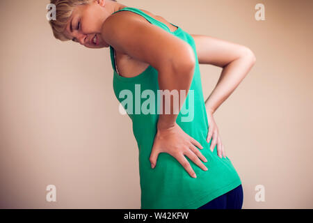 Woman with short hair feels strong pain in back isolated. People, healthcare and medicine concept Stock Photo