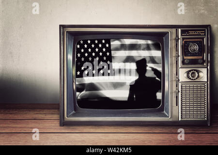 silhouette of soldier on american flag in vintage television on wooden table. Independence day , National american holiday. Stock Photo