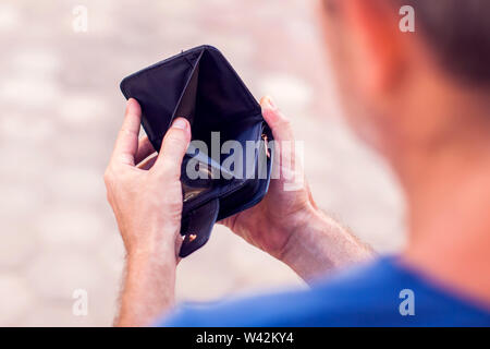 Man holds an empty wallet in hands. Stock Photo