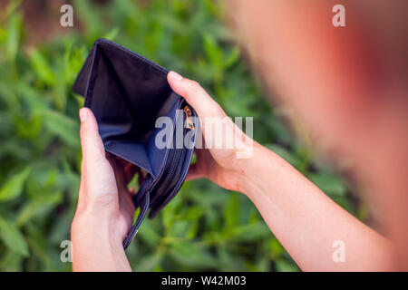 Man holds an empty wallet in hands. Stock Photo