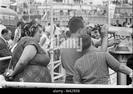 Holiday scenes at Brighton.Holidaymakers on Brighton's promenade look out on the English Channel by using one of the councils many coin operated tourist telescopes. 7th July 1963 Stock Photo