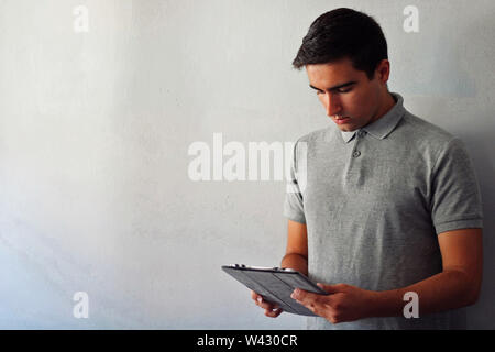 Man dressed in gray using a tablet. Stock Photo