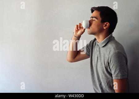 Man dressed in gray drinking a cup of coffee. Stock Photo