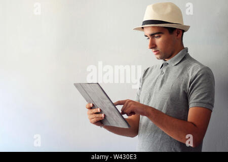 Man dressed in gray using a tablet. Stock Photo