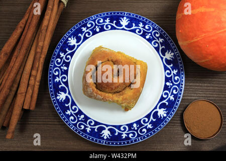 Halloween autumn pumpkin yeast bun with cinnamon on decorative plate Stock Photo