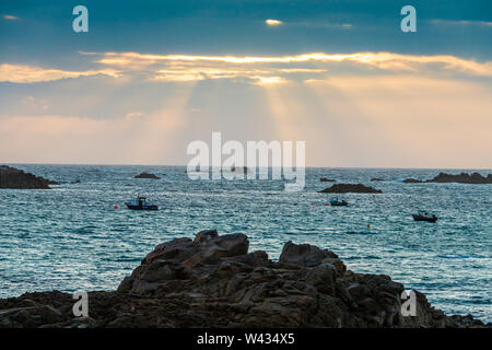 The sun setting over Cobo Bay, Guernsey, Channel Islands UK Stock Photo