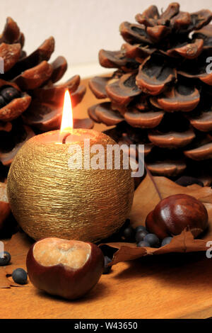 Autumnal decoration with horse chestnuts leaves and candle Stock Photo