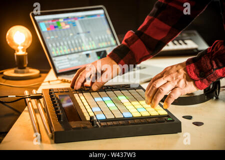 Electronic music producer using a Push midi pad controller with Ableton Live on a Macbook pro Stock Photo