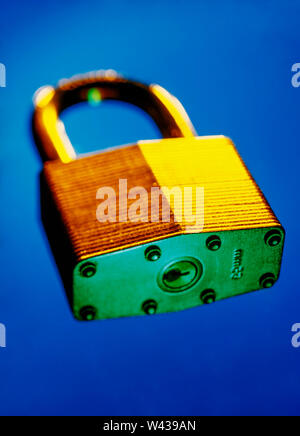 Colourful image of a golden padlock with a short depth of field  floating on a blue background Stock Photo
