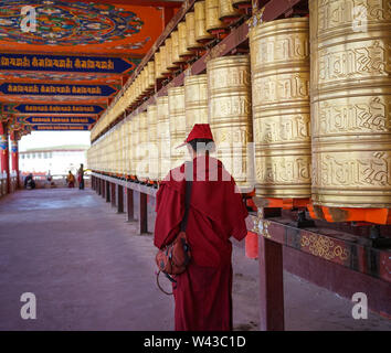 Sichuan, China - Aug 18, 2016. A monk using prayer wheels at Yarchen Gar in Sichuan, China. Yarchen Gar is the largest concentration of nuns and monks Stock Photo