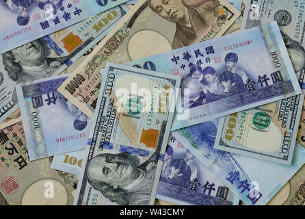 Many kind of banknotes - close up. US dollar, Japan yen and Taiwanese dollar. Stock Photo