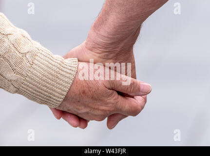 Elderly Couple hands of elderly couple walking in a Street Stock Photo