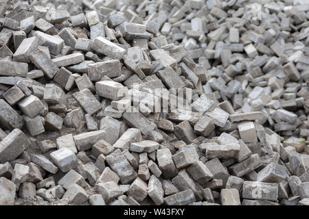 Pile of dismounted gray modern urban pavement bricks with selective focus. Result of russian government corruption in city infrastructure renovation. Stock Photo