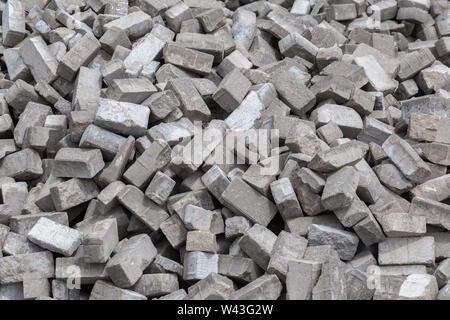 Pile of dismounted gray modern urban pavement bricks with selective focus. Result of russian government corruption in city infrastructure renovation. Stock Photo