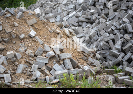 Pile of dismounted gray modern urban pavement bricks with selective focus. Result of russian government corruption in city infrastructure renovation. Stock Photo