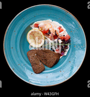 Appetizer of shrimps, tomatoes and sour cream isolated on black Stock Photo