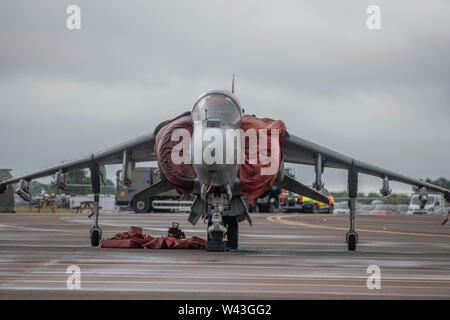 RAF Fairford, Glos, UK. 19th July 2019. Day 1 of The Royal International Air Tattoo (RIAT) with military aircraft from around the world assembling for the world’s greatest airshow which runs from 19-21 July. Day 1 flying display is heavily curtailed due to low cloud base, heavy rain and high winds. Image: Static display of military aircraft under grey skies. Image: Spanish Navy VTOL Harrier EAV-8B aircraft on the apron. Credit: Malcolm Park/Alamy Live News. Stock Photo