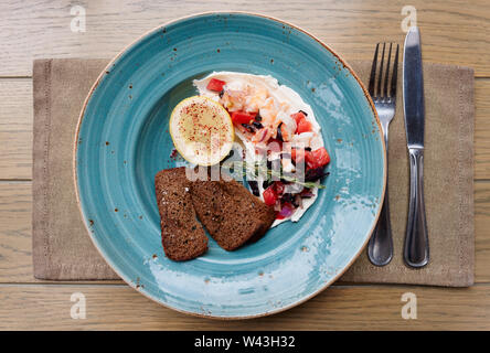 Appetizer of shrimps, tomatoes and sour cream with rye bread toasts Stock Photo