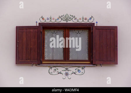 Close up view of an open wooden window on decorated white wall. Summer in the Pennine Alps, Valle d'Aosta, Italy, Europe. Stock Photo