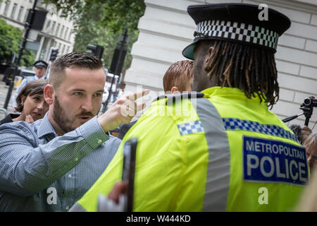 London, UK. 19th July 2019. James Goddard, 30, from Timperley in Altrincham, confronts a police officer outside Westminster Magistrates' Court. The self-styled leader of the UK's 'yellow vest' pro-Brexit nationalist movement faces a two-day trial of harassment charges after Tory MP Anna Soubry was called a “nazi”, “traitor” and “scum” whilst walking to the House of Commons between December 18th last year and January 8th. Goddard has also admitted to racially abusing a police officer outside parliament. Ms Soubry herself is expected to give evidence. Credit: Guy Corbishley/Alamy Live Stock Photo