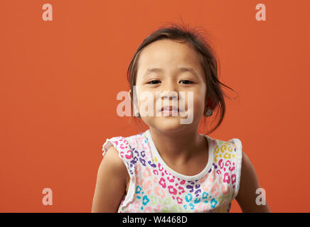 Asian kid being serious on a color background. Stock Photo