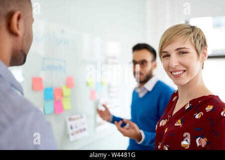 Platinum pixie cut female boss led multi-ethnic group hipster trendy business people during a brainstorm session for their small company Stock Photo