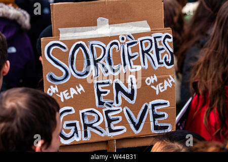 A close up view of a French poster, saying witches on strike, held above a crowd of ecological activists during a peaceful protest in Montreal, Canada Stock Photo